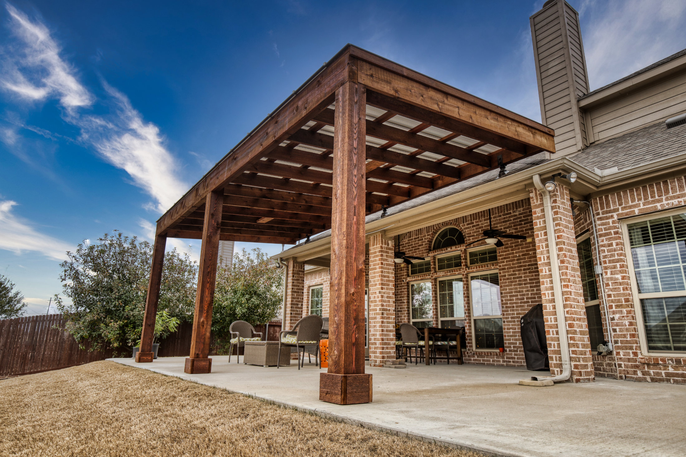 Freestanding cedar pergola with ceiling fan on concrete pad